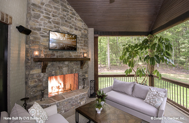 Screened porch with outdoor fireplace from The Carrera house plan 1178.