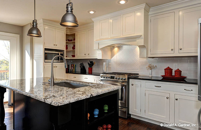 White cabinets and recessed lighting in the kitchen. The Barclay plan 248.