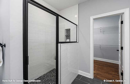 Nice white walking shower with accent flooring with closet off to the side. Applecross plan 1501