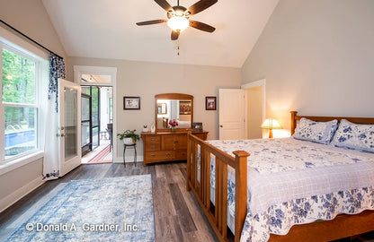 The master bedroom is a quiet retreat with access to the rear porch in one story house plan 1506 The Ashbry