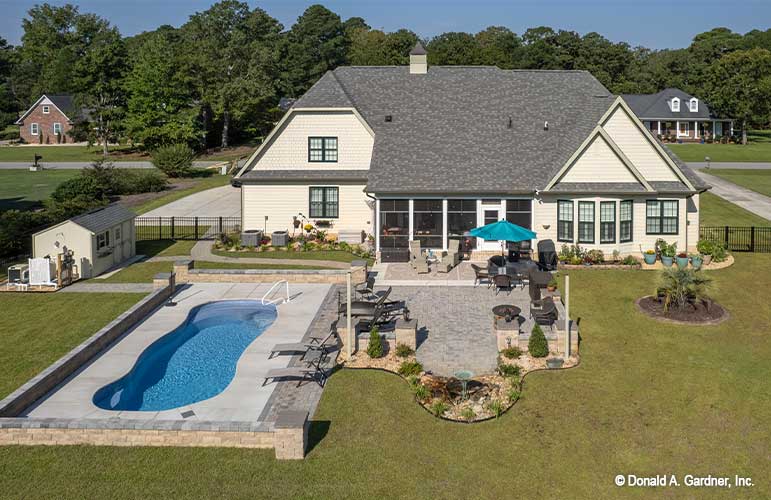 Rear photograph displaying the full back yard with a pool. The Avant plan 1346.