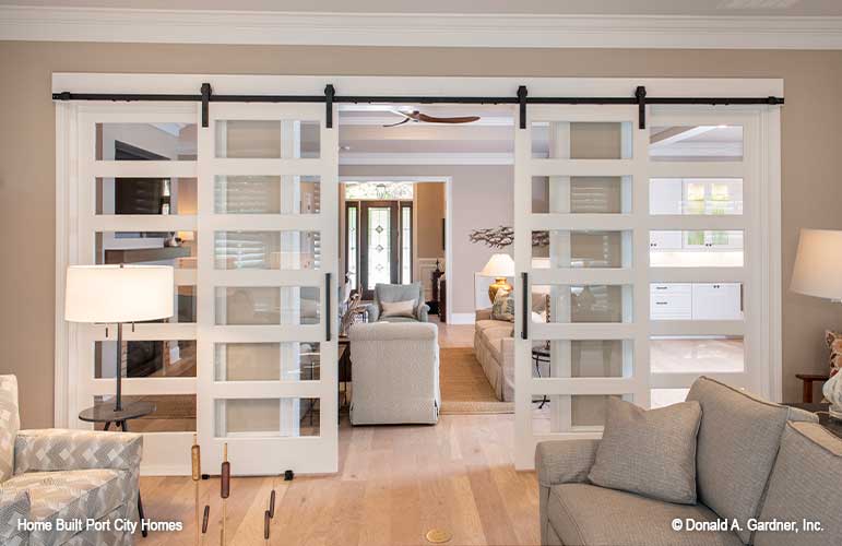 Sliding barn style doors separating the sitting and great room. The Barlett plan 1372. 