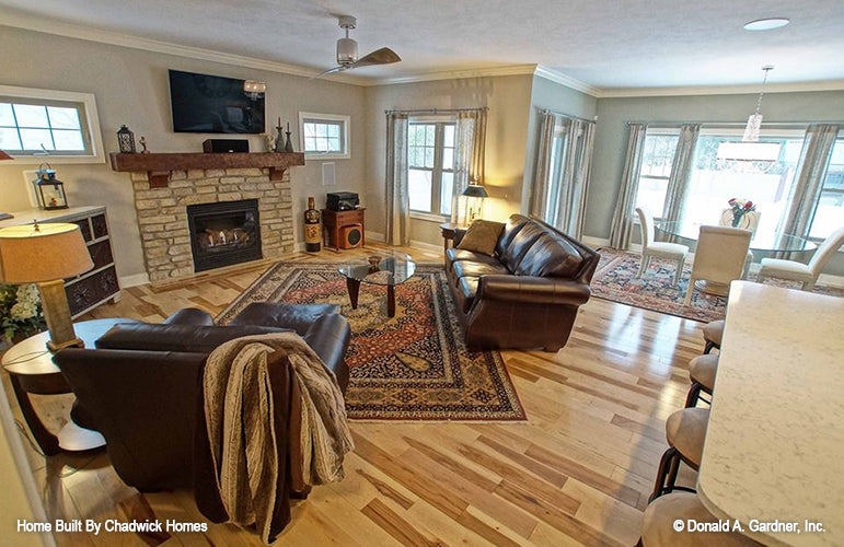 Stone fireplace with wood mantel in the great room. The Beauxville plan 1236.