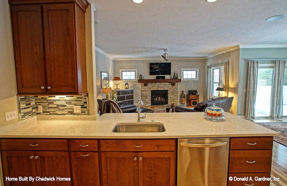 Wood-stained cabinets in the kitchen. The Beauxville plan 1236.