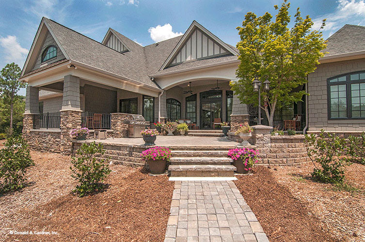 Stone walkway leading to the steps of the rear porch. The Birchwood plan 1239.