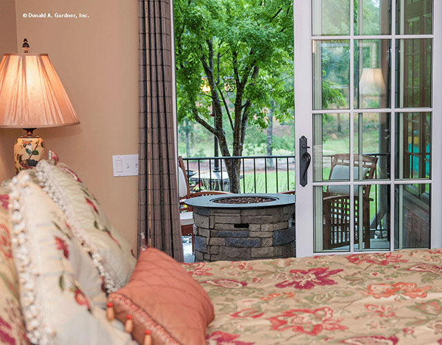 Sliding glass door open in the master bedroom leading to the outdoor firepit. The Birchwood plan 1239.