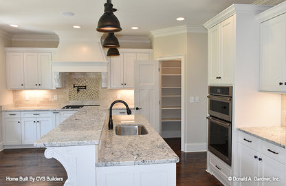 All white cabinets and wood flooring in the kitchen. The Brogan plan 947.