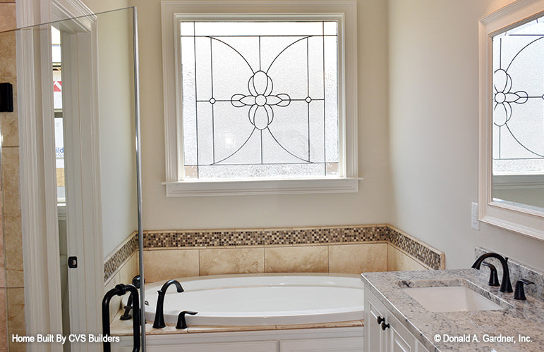 Soaking tub with a window above in the master bathroom. The Brogan plan 947.