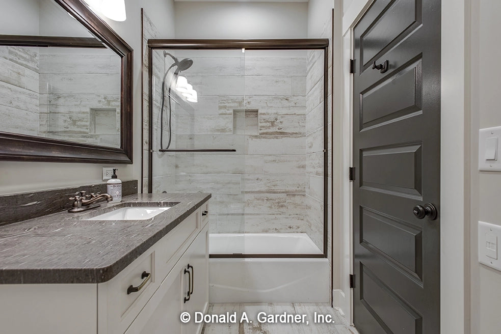 Bathroom with stone tile in shower area and single vanity