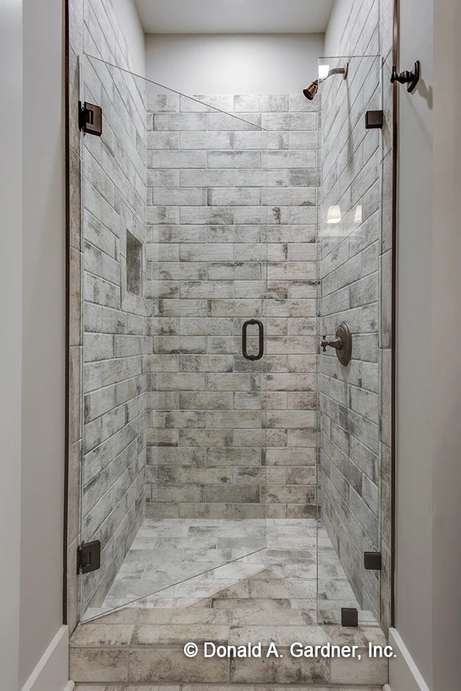 Walk-in shower with stone tile work with glass door