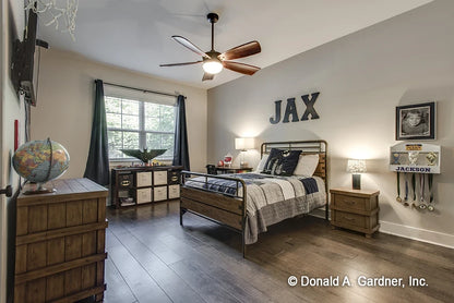 Secondary bedroom with a large window and hard wood floors