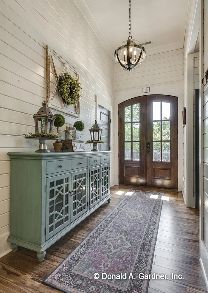 Foyer with arched top front door crown molding and beautiful wood flooring