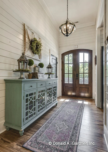 Foyer with arched top front door crown molding and beautiful wood flooring