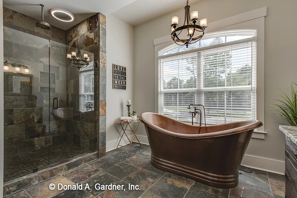 Elegant copper soaking tub and stone walk-in shower in the master bathroom