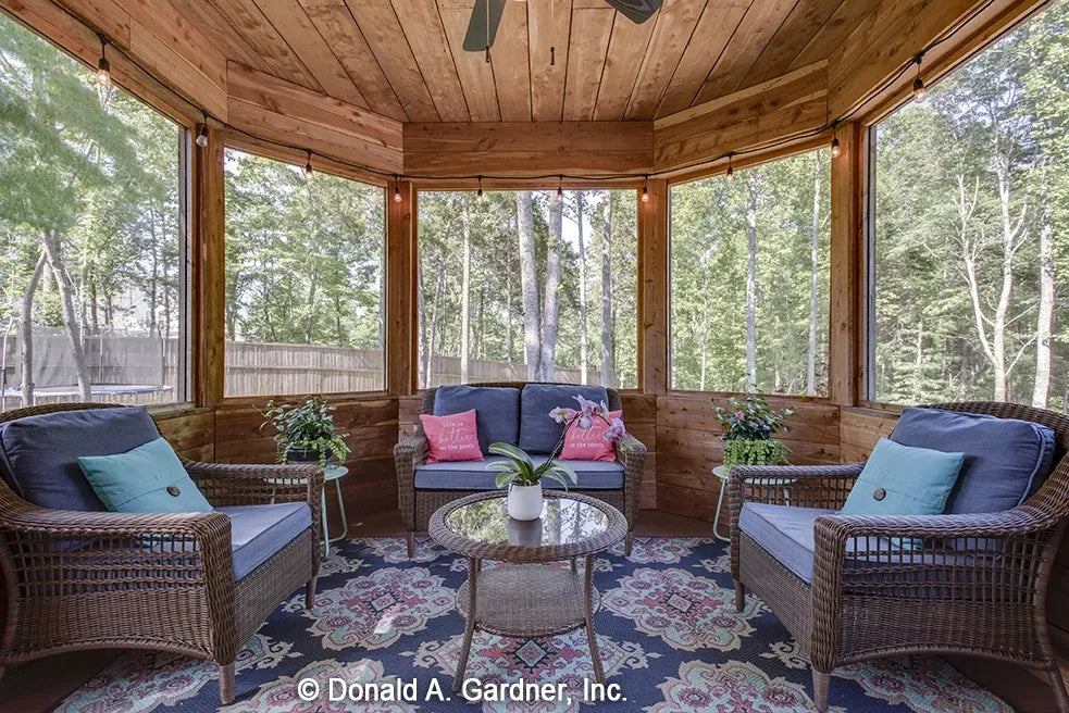 Screened porch with wood wall treatments and wicker furnishings