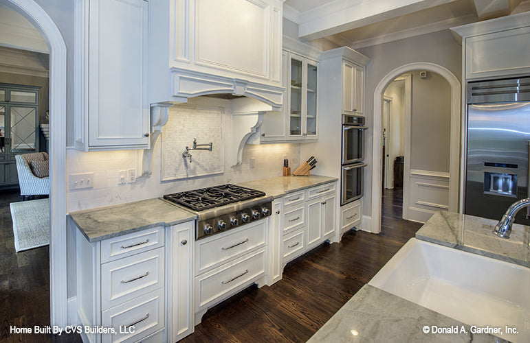 White cabinets and range hood in the kitchen. The Carrera plan 1178.