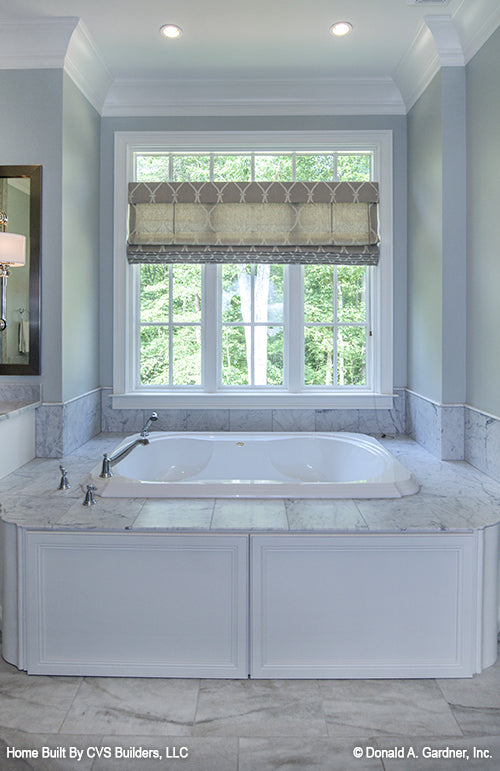 Large window with a soaking tub beneath in the master bathroom. The Carrera plan 1178.