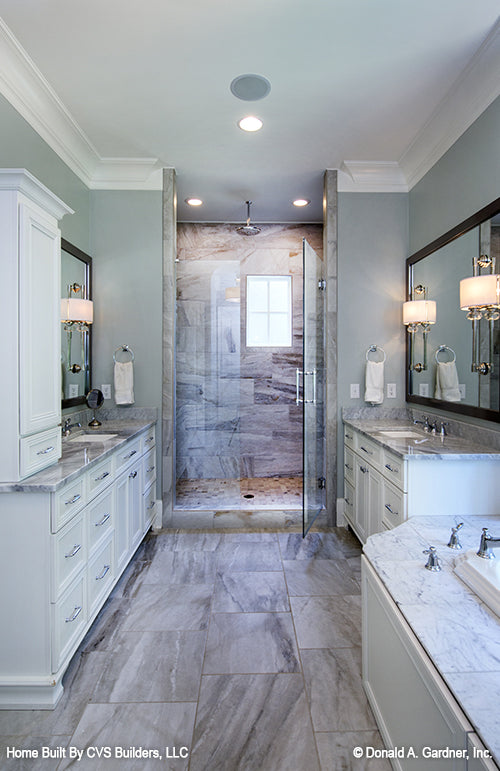 Isle view of the master bathroom with single vanities on either side of the walk-in shower. The Carrera plan 1178.