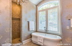 Stand alone soaking tub with windows behind int he master bathroom. The Cedar Court plan 5004.