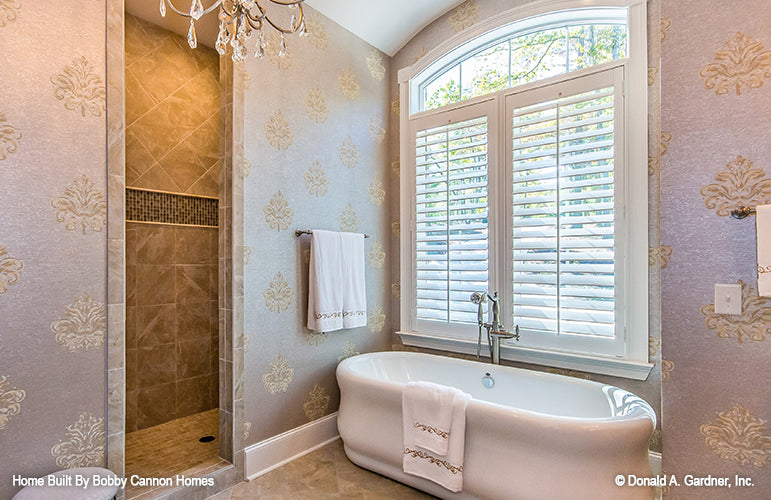 Stand alone soaking tub with windows behind int he master bathroom. The Cedar Court plan 5004.