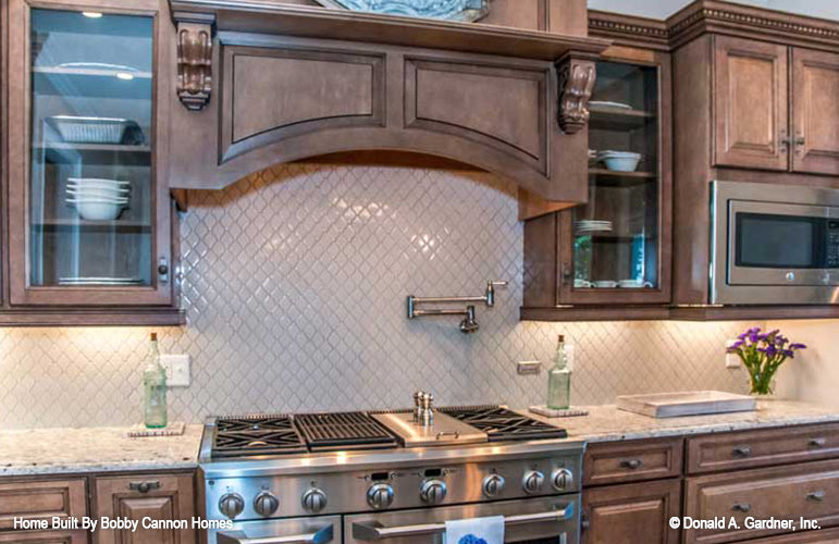 Stained wood cabinets in the kitchen. The Cedar Court plan 5004.