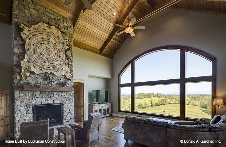 Large arched window with gorgeous view in the great room. The Cedar Creek plan 959 