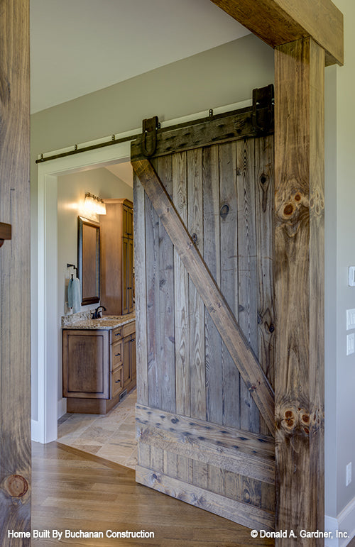 Farmhouse style sliding doors to the master bathroom. The Cedar Creek plan 959 