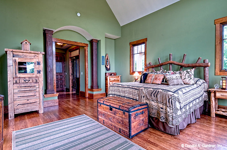 Wood flooring and green walls in the master bedroom. The Chanticleer plan 810.