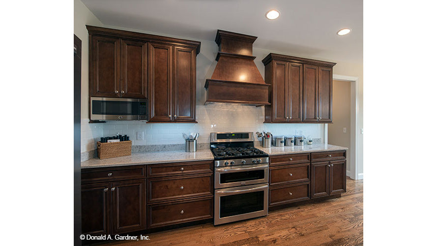 White subway tile and brown cabinets in the kitchen. The Charlevoix plan 1068.