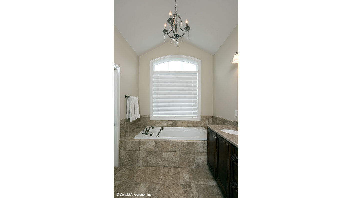 Soaking tub with a chandelier above in the master bathroom. The Charlevoix plan 1068.