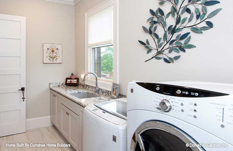 Utility room with a sink off to the side of the washer and dryer. The Chatsworth plan 1301.