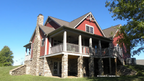 Rear side view, red siding and stone. The Chestnut Hill plan 1244.