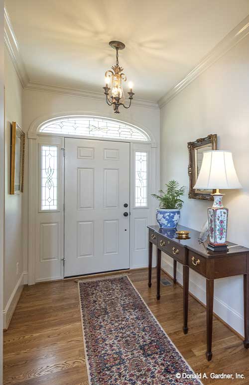 Inviting foyer with arched window above the front door. The Cline plan 1419