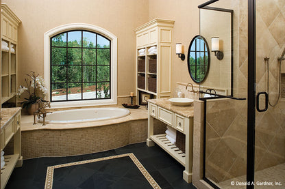 Arched window above the sitting tub in the master bathroom. The Clubwell Manor plan 5037. 