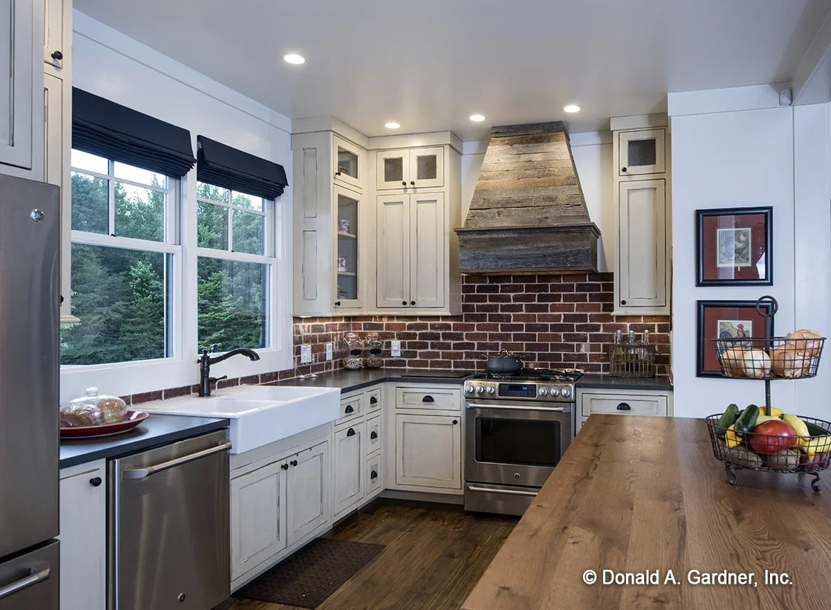 A brick backsplash highlights the kitchen of modern farmhouse house plan 1335 The Coleraine