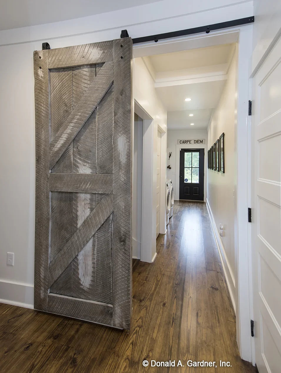 A barn door hides the utility room in modern farmhouse house plan 1335 The Coleraine