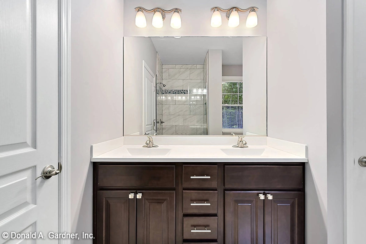 Dual bathroom vanity and large mirror showing the tile walk-in shower