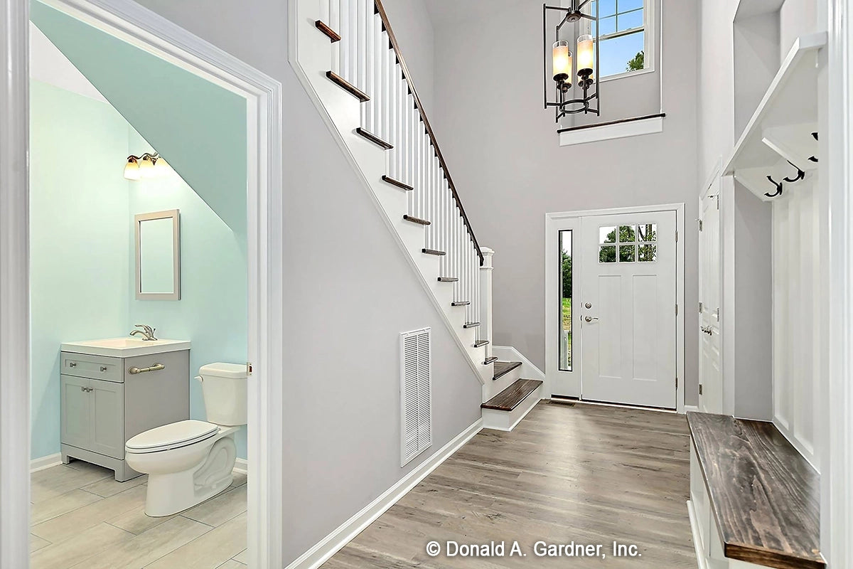 Two story foyer with half bath under the stairs