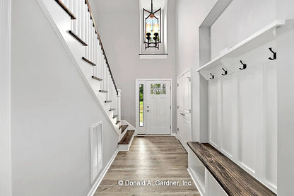 Welcoming foyer with drop zone that features a built-in bench, hooks and shelf