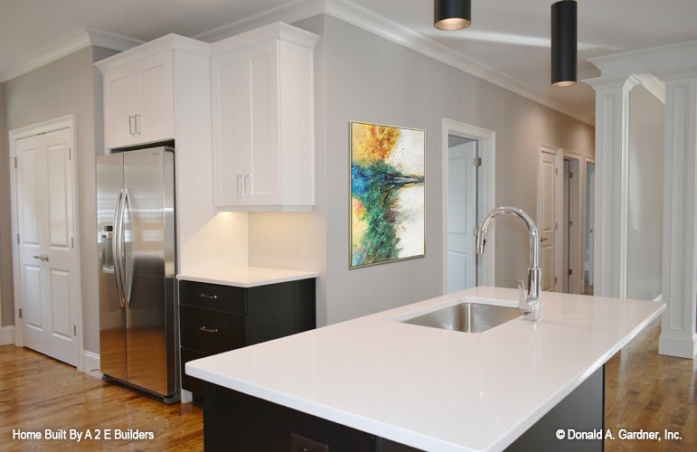 This is a picture of the kitchen island and open space of house plan 1025 The Currier