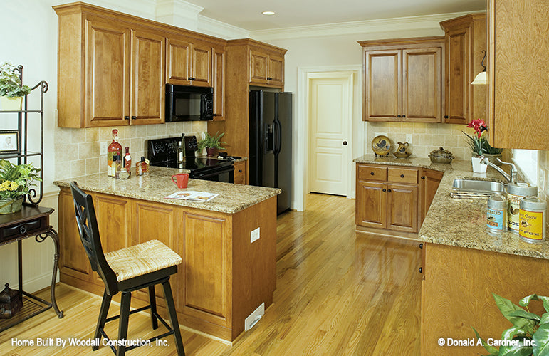 Brown cabinets and tiled backsplash in the kitchen. The Dayton plan 1008.