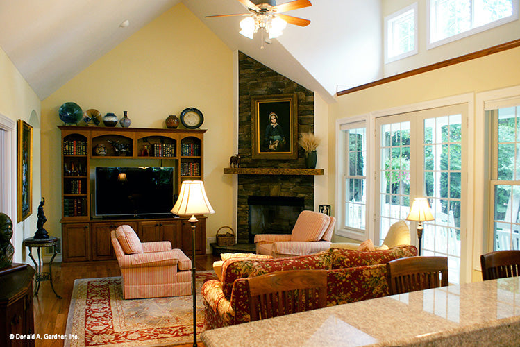 Corner fireplace with stone from floor to ceiling in the living room. The Edelweiss plan 1013.