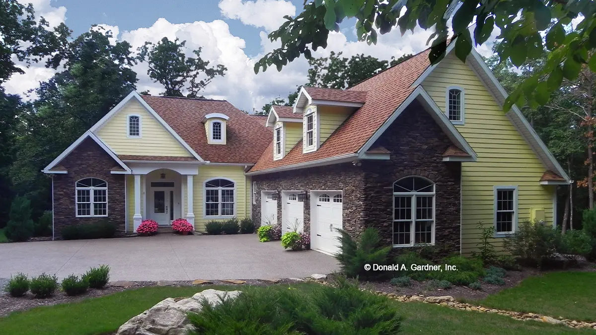 Front view photograph with courtyard three car garage. Photographs submitted by the customer. The Edelweiss plan 1013.