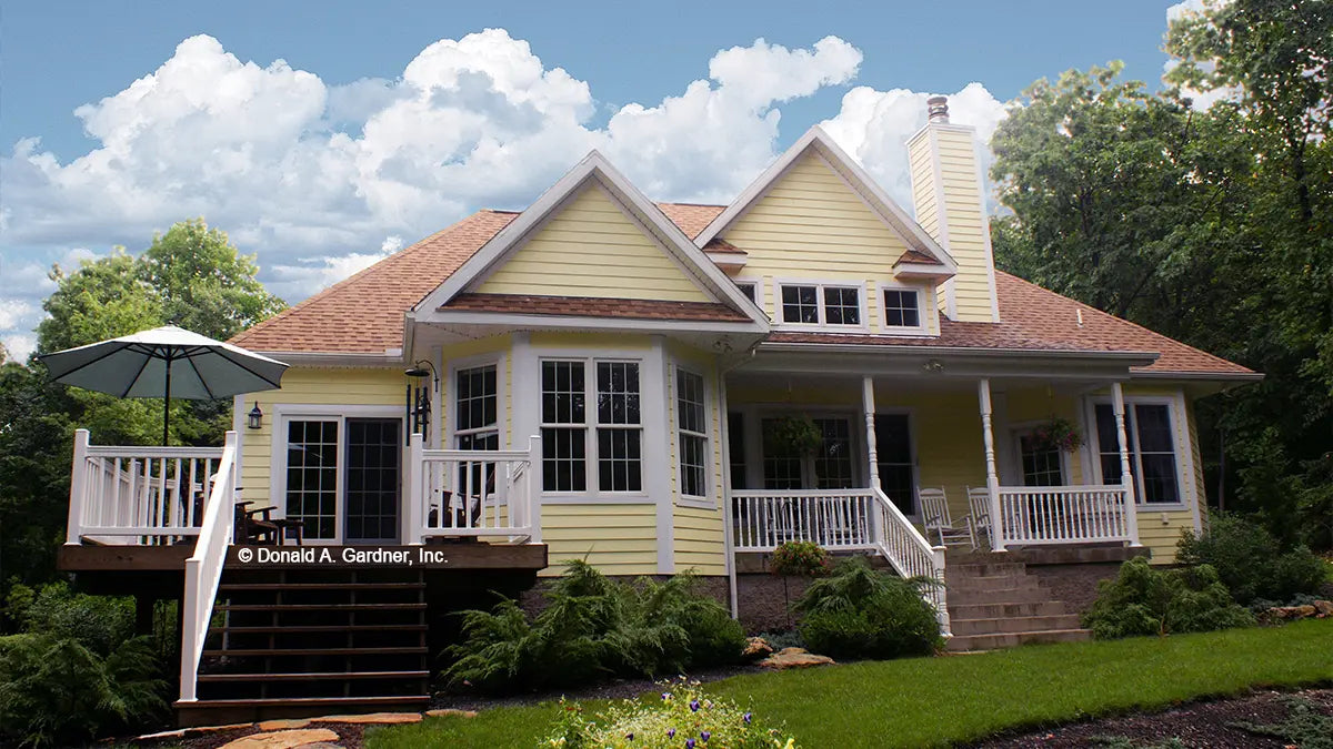 Rear view photograph with a deck and covered porch. The Edelweiss plan 1013.