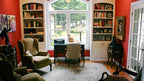 Arched window and built in bookcases in the study. The Edelweiss plan 1013.