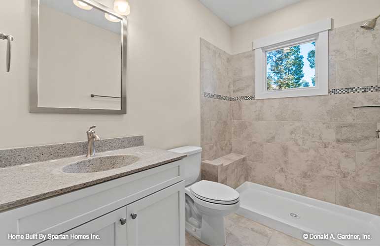 Single sink vanity and walk-in open shower in the bathroom. The Ella plan 1344.