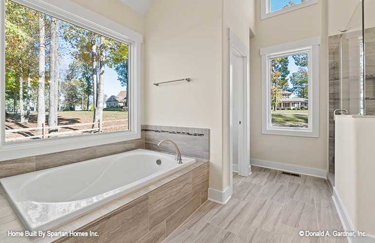 Soaking tub next to large window in the master bathroom. The Ella plan 1344.