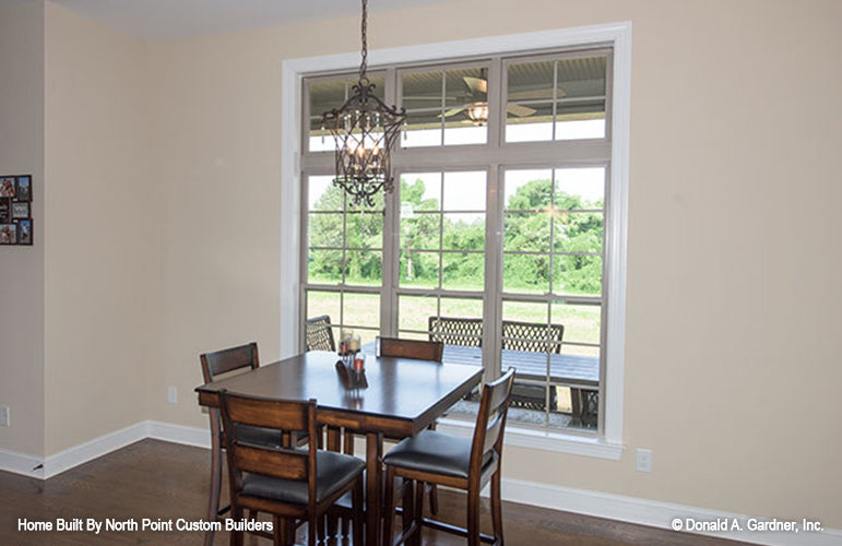 Large window and chandelier in the dining room. The Foxglove plan 1297.