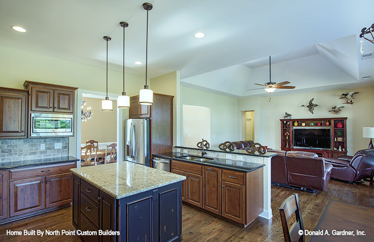 Island with pendant lights above in the kitchen. The Foxglove plan 1297.