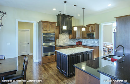 Brown cabinets and recessed lights in the kitchen. The Foxglove plan 1297.